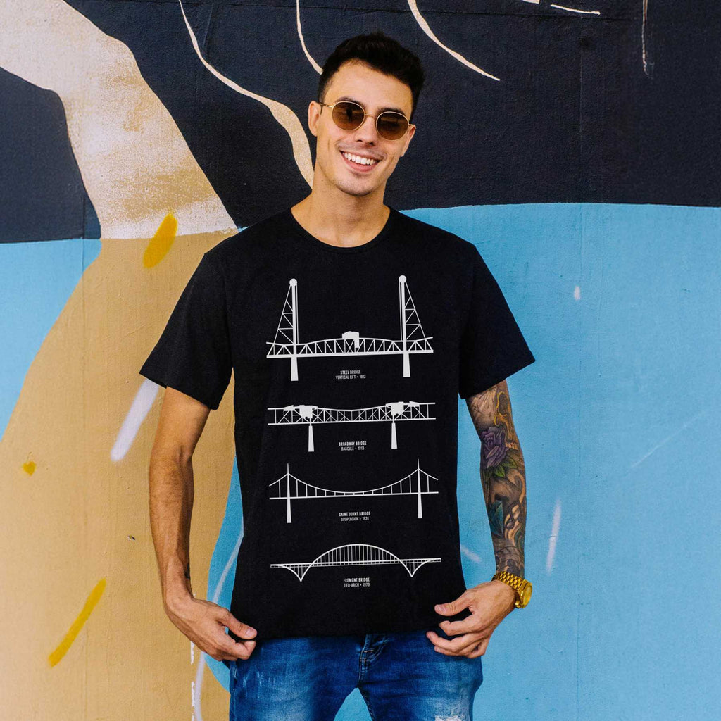 Rose City Roots Portland graphic tee — white on black worn by model in front of mural